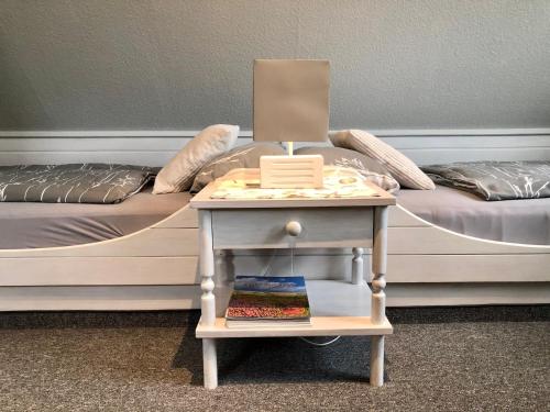 a bed with a table next to a bed with a side table at Appartements Friedrichsen in List