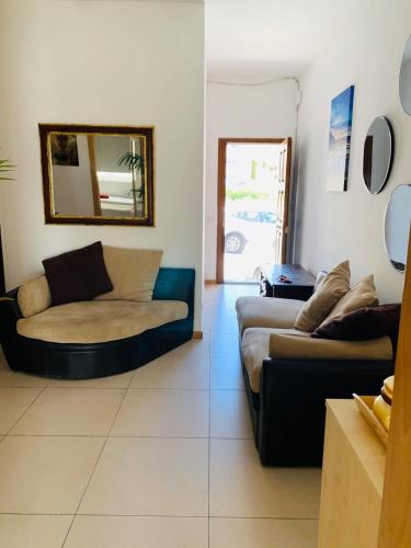 a living room with a couch and a mirror at Hostel Malti Budget in St Julian's