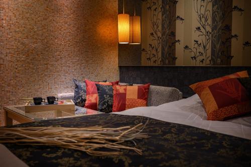 a bedroom with a bed with colorful pillows at HOTEL C.KOHOKU in Shin-yoshidamachi