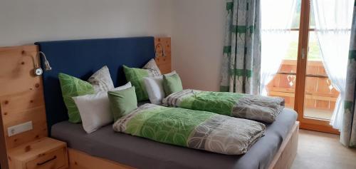 um sofá com almofadas num quarto com uma janela em Ferienwohnungen Am Kranzbach FeWo1 em Krün