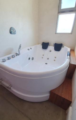 a white bath tub in a bathroom with a window at Ammunaini in Punta Del Diablo