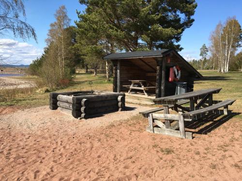 a picnic shelter with a picnic table and benches at Dalastugan in Mora