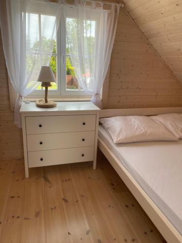 a bedroom with two beds and a lamp on a dresser at Mamma Mia Resort in Łukęcin