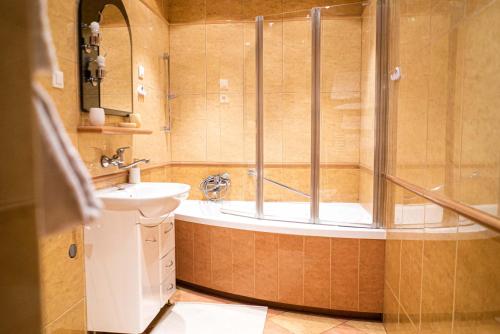 La salle de bains est pourvue d'une baignoire, d'un lavabo et d'une douche. dans l'établissement BOROWE KT, à Warka