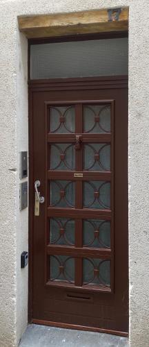 une porte marron avec des panneaux de verre sur un bâtiment dans l'établissement Le Standing - Au Coeur d'Agen - Self Checkin - Wifi - Netflix - Smart TV - Luqs fr, à Agen