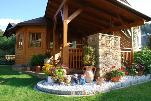 a small house with a fountain in the yard at FeWo Wassertheurer in Tröpolach