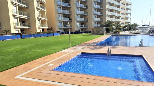 una piscina frente a un gran edificio de apartamentos en PORT GRAN - MAJESTIC - ROSES - COSTA BRAVA en Rosas