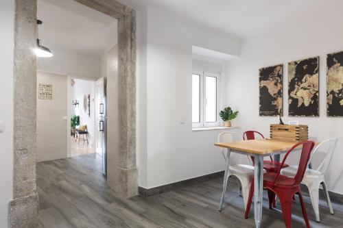 a dining room with a table and red chairs at Panoramic Graça Duplex with Castle and River Views by NestAtLisbon in Lisbon