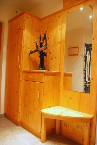 a room with a wooden wall with a bench and a mirror at FeWo Wassertheurer in Tröpolach