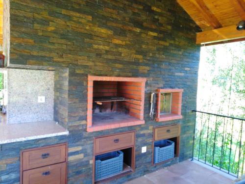 a brick wall with a stove in a kitchen at Cantinho do Lucas in Alvaiázere