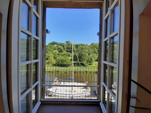 an open window with a view of a sheep outside at Vue sur le port de Dinan in Dinan