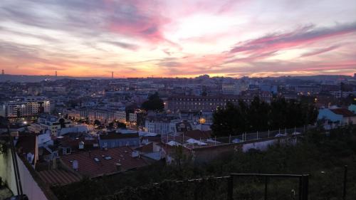 a view of a city at sunset at Panoramic River View 1-BR near Senhora do Monte by NestAtLisbon in Lisbon