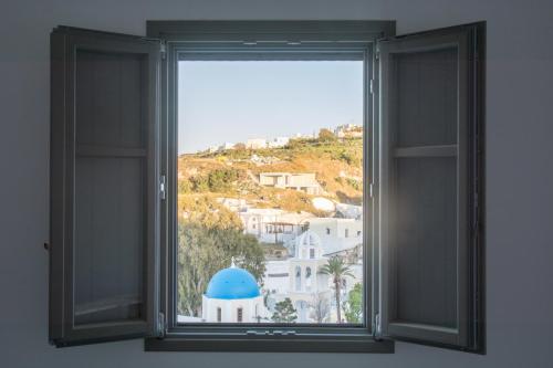 an open window with a view of a city at Amphitrite Suites Santorini in Vóthon
