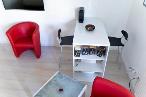 a room with a white table and red chairs at Ferienwohnung Dennis in Lörrach