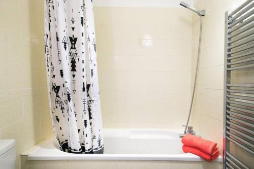 um chuveiro com uma cortina de chuveiro preto e branco na casa de banho em Studio neuf proche Disneyland Paris em Meaux