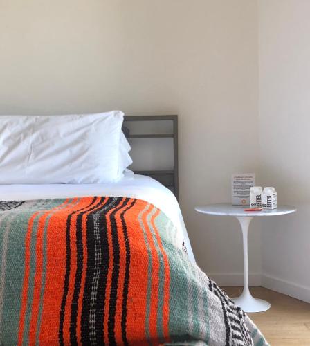 a bedroom with a bed with a table next to it at The M Malibu in Malibu