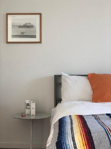 a bedroom with a bed and a table with a picture on the wall at The M Malibu in Malibu