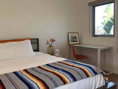a bedroom with a bed and a desk and a window at The M Malibu in Malibu
