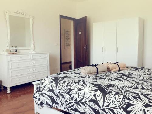 a bedroom with a black and white bed and a dresser at Villa Sofia in Pramaggiore