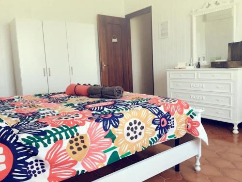 a bedroom with a bed with a floral bedspread at Villa Sofia in Pramaggiore