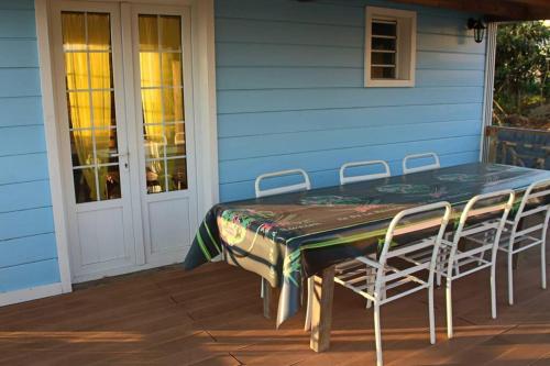 einen Tisch und Stühle auf der Veranda eines Hauses in der Unterkunft Villa de charme - la plaine des cafres in La Plaine des Cafres
