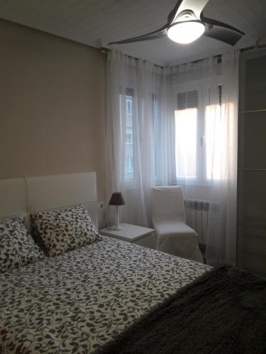a bedroom with a bed and a chair and a window at Céntrico y acogedor en tierra de vinos in Logroño