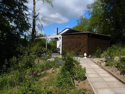a garden with a house and a walkway at Waldhütte am See in Klingberg