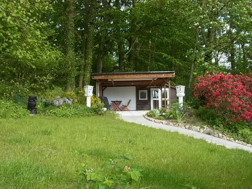 a small shed in a garden with a grass yard at Waldhütte am See in Klingberg
