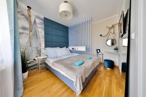 a bedroom with a large bed with a blue headboard at Klif Residence in Władysławowo