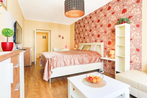 Un dormitorio con una cama y una mesa con un bol de fruta en Apartment Carla, en Karlovy Vary