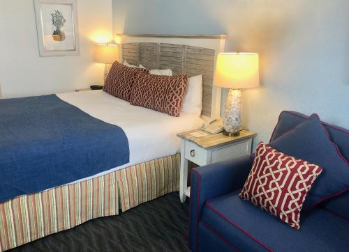 a hotel room with a bed and a blue chair at Beach View Hotel in Rehoboth Beach