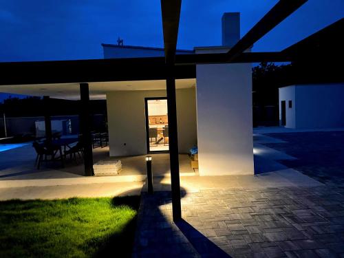 a house with a lit up patio at night at Villa Eni Medulin Sisan heated pool in Šišan