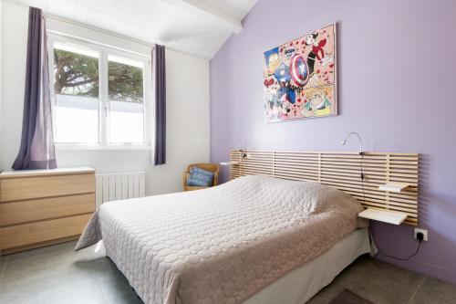 una camera da letto con un letto bianco e una finestra di Villa Ensoleillée a Sainte-Marie-de-Ré