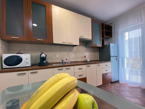 uma cozinha com um monte de bananas num balcão em Family Beachfront Apartment em Petrovac na Moru