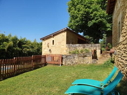 a blue chair in a yard next to a building at Le Clos de la Canéda in Sarlat-la-Canéda