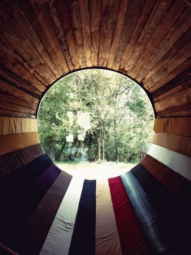 a view of a bed through a round window at Kačara Vodeničko brdo in Pranjani