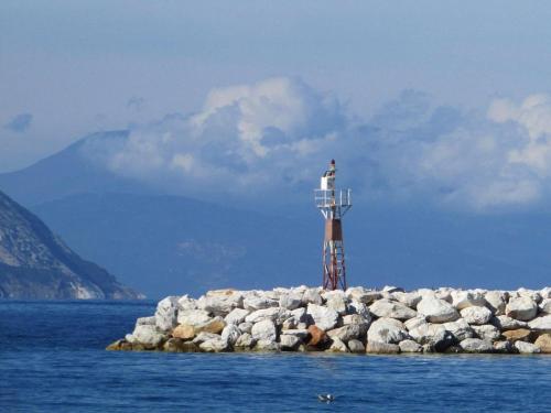 a lighthouse on a small island in the water at SK studios & apartments in Neo Klima