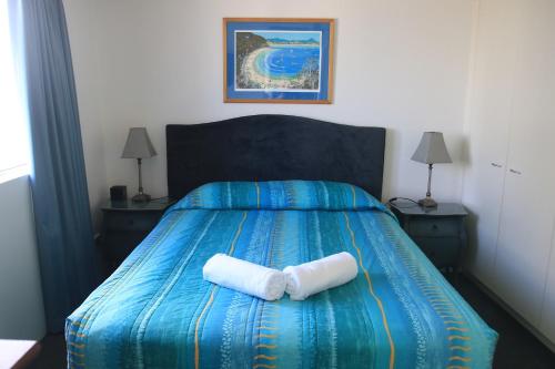 a bedroom with a bed with two white towels on it at Centrepoint Apartments Caloundra in Caloundra