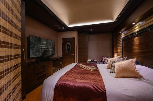 a bedroom with a large bed and a flat screen tv at HOTEL C.KOHOKU in Shin-yoshidamachi
