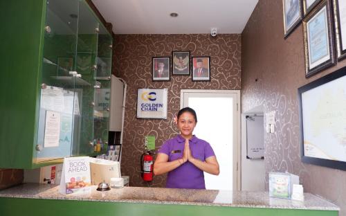 a woman standing behind a counter in a kitchen at Ara Inn Bed And Breakfast by ecommerceloka in Kuta