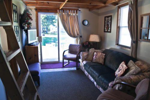 a living room with a couch and a window at Cabin #7 - Northwoods Retreat cabin in Carp Lake