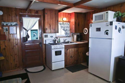 Una cocina con un refrigerador blanco y una estufa. en Cabin #1 - Cedar Village cabin, en Carp Lake