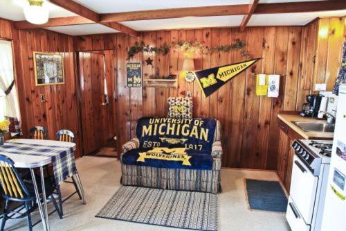 a kitchen with wooden walls and a kitchen with aintendent of michigan sign at Cabin #2 - M Den cabin in Carp Lake