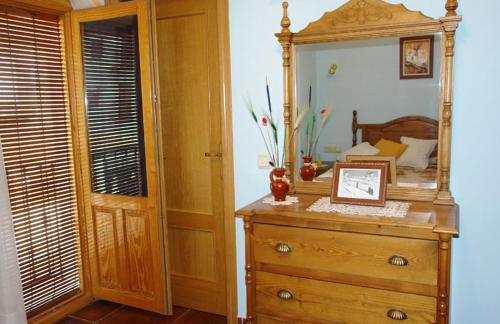 a bedroom with a dresser with a mirror on it at Hostal Restaurante Ego's in Campo de Criptana