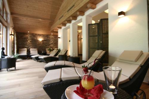 a restaurant with chairs and a table with a drink at Hotel Hindenburglinde in Ramsau