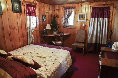 Schlafzimmer mit einem Bett, einem Schreibtisch und einem Stuhl in der Unterkunft Cabin #6 - Casablanca cabin in Carp Lake