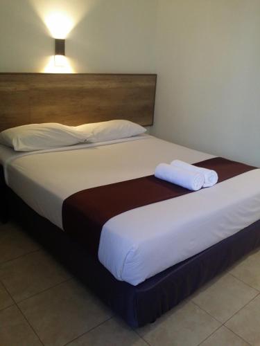 a large bed with two towels on top of it at Seremban Inn in Seremban