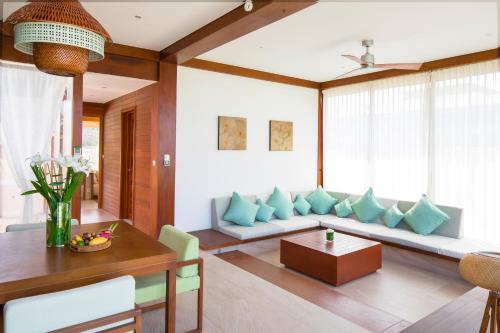 a living room with a couch and a table at Fusion Resort Cam Ranh - All Spa Inclusive in Cam Ranh