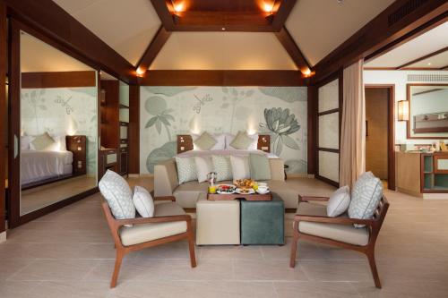 a living room with a couch and two chairs at Fusion Resort Cam Ranh - All Spa Inclusive in Cam Ranh