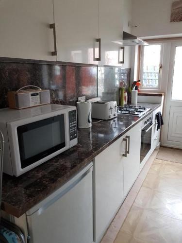 une cuisine avec un four micro-ondes et des appareils sur un comptoir dans l'établissement Carvetii - Gemini House - 4 bed House sleeps up to 8 people, à Tillicoultry